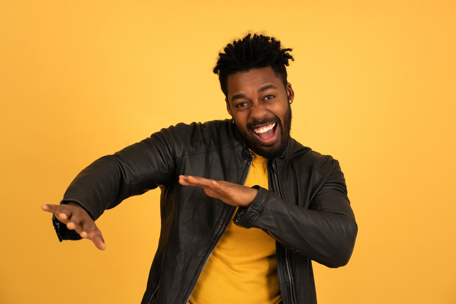 Cheerful Afro Man Dancing While Standing against an Isolated Bac